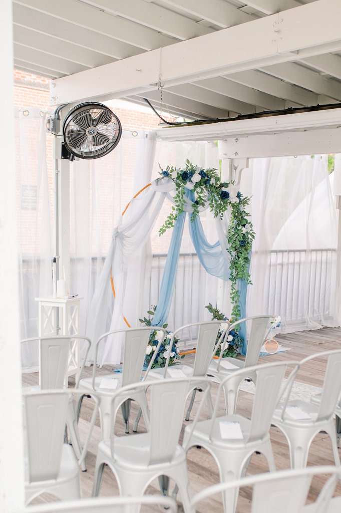 Chairs and a wedding arch set up on a rooftop deck.